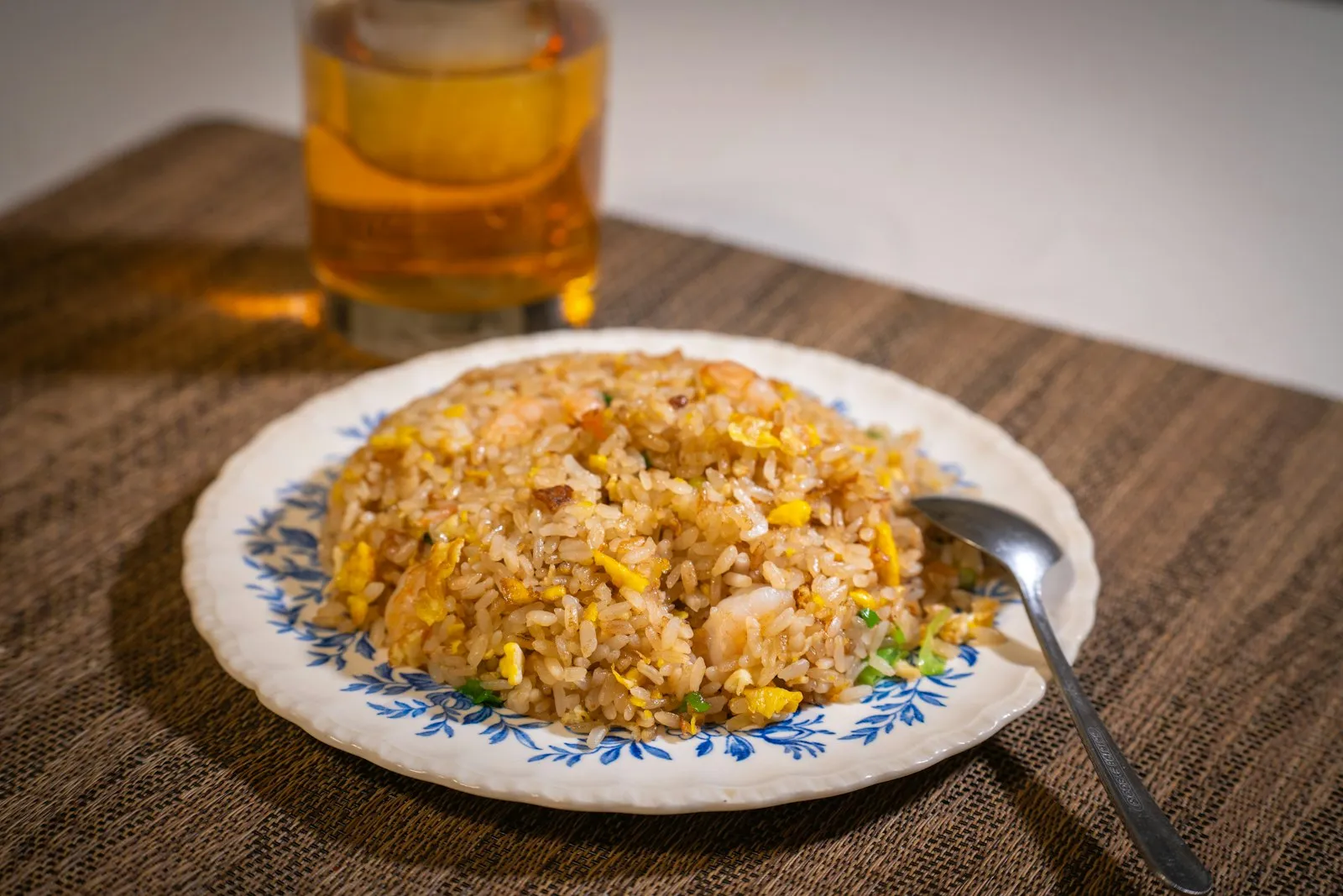 Plate of egg fried rice with scrambled egg and vegetables and a spoon